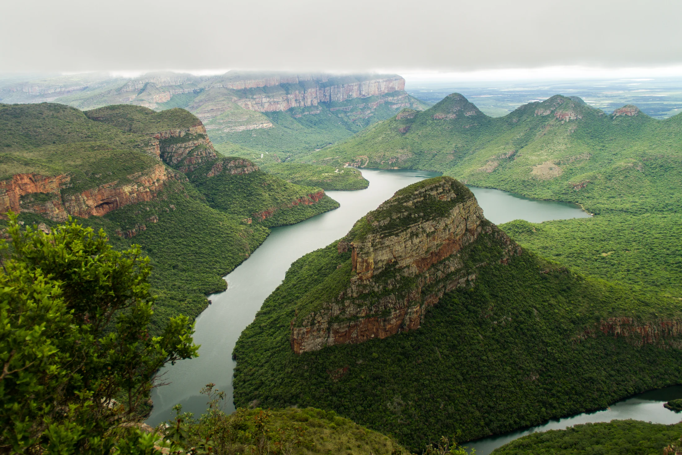 Water and steep ridges in a wide view across Blyde River Canyon